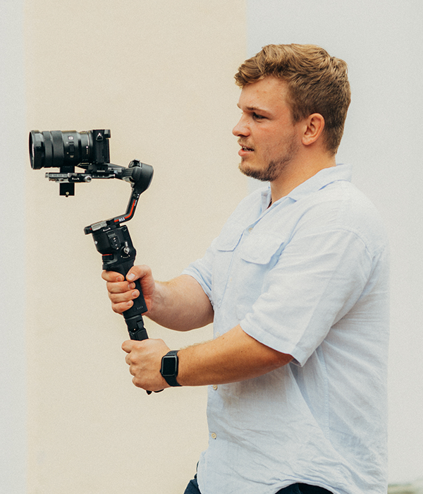 Person hat Gimbal mit Kamera in der Hand.